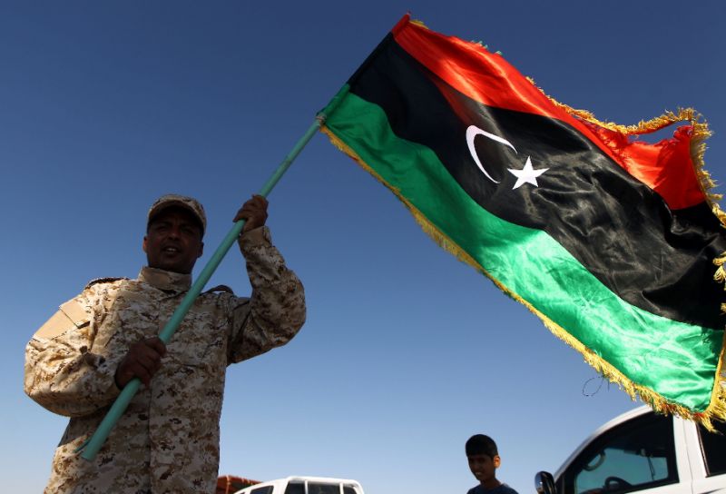 A member of forces opposed to Libya's unity government waves a Libyan flag at the Zueitina oil terminal