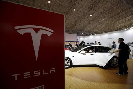 People visit a Tesla Model S car during the Auto China 2016 in Beijing