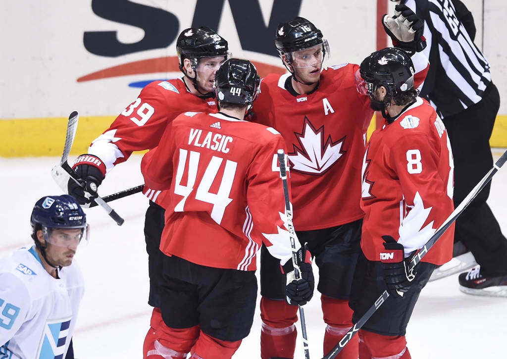 Team Canada centre Jonathan Toews celebrates with teammates as Team Europe defenceman Roman Josi skates by during third period World Cup of Hockey action in Toronto on Wednesday