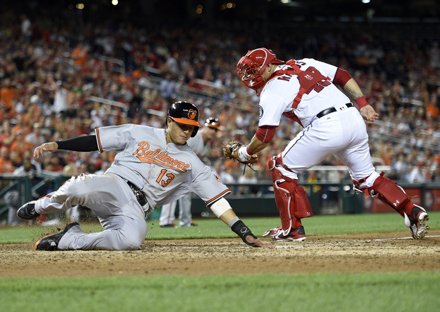 Baltimore Orioles Manny Machado slides home past Washington Nationals catcher Wilson Ramos to score on single by Jonathan Schoop during the eighth inni