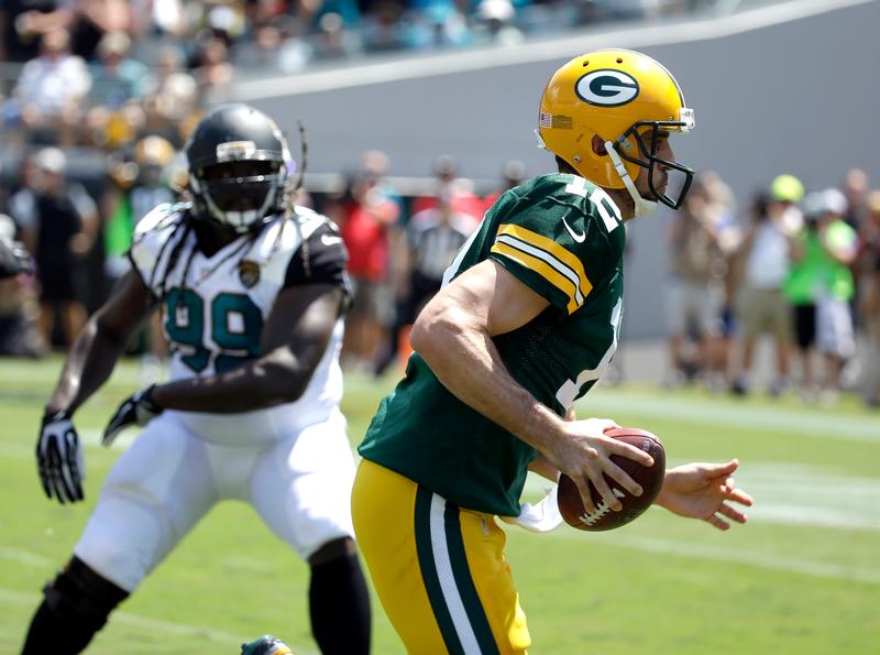 Green Bay Packers quarterback Aaron Rodgers runs for a 6-yard touchdown past Jacksonville Jaguars defensive tackle Sen'Derrick Marks during the first half