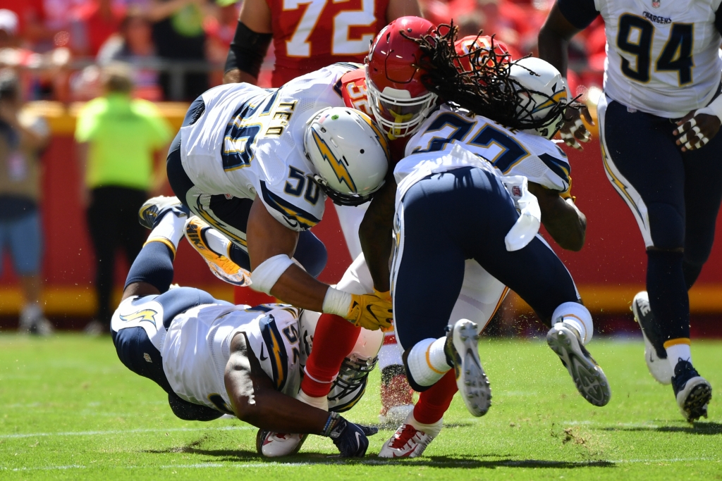 Running back Spencer Ware #32 of the Kansas City Chiefs is gang tackled by Manti Te'o #50 Jahleel Addae #37 and Denzel Perryman #52 of the San Diego Chargers during the game at Arrowhead Stadium