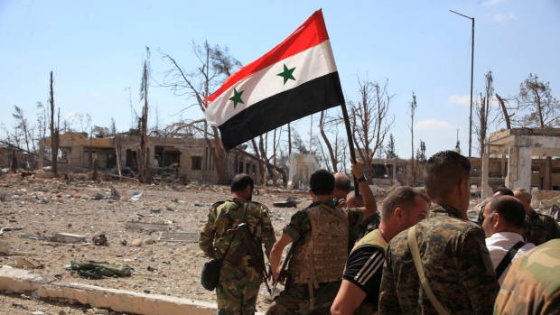 Forces loyal to Syria's President Bashar al Assad walk at a military complex after they recaptured areas in southwestern Aleppo on Sunday that rebels had seized last month