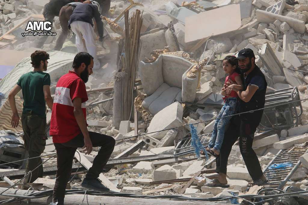 Syrian anti-government activist group Aleppo Media Center, shows a Syrian man carrying a girl away from the rubble of a destroyed building after barrel bombs were dropped on the Bab al Nairab neighborhood in Aleppo Syria