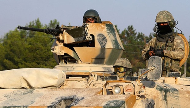 Turkish soldiers on an armored personnel carrier drive toward Karkamis