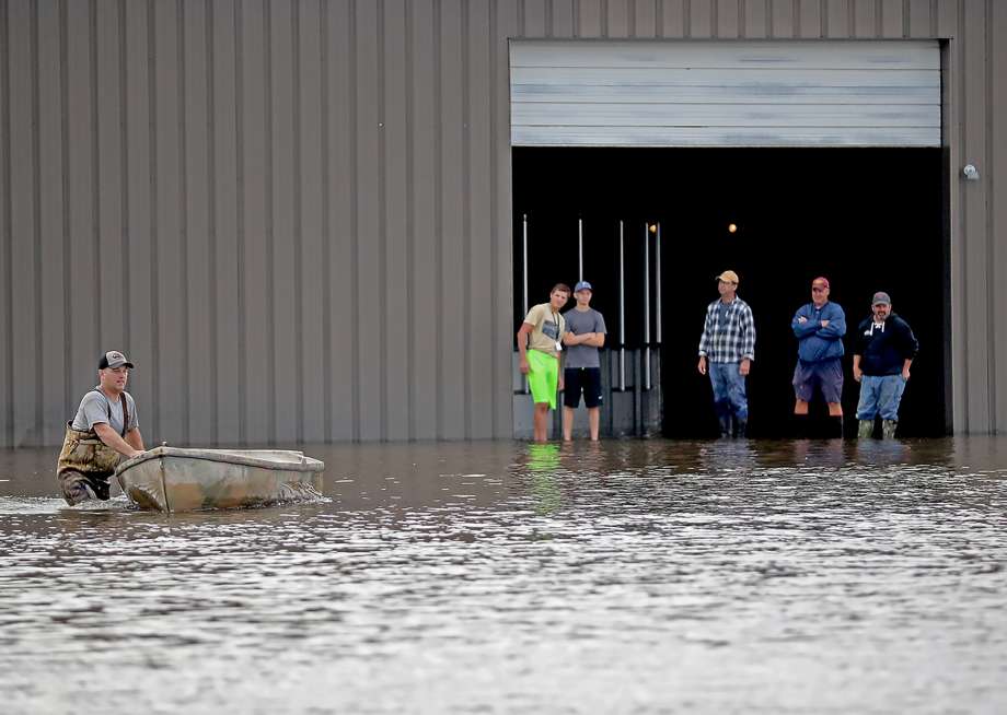 Men stand around to help sand the ice arena near the Waseca High School Thursday Sept. 22 2016 in Waseca Minn. Thursday Sept. 22 2016. Several Midwestern states were a soggy mess Thursday after up to 10 inches of rain fell in parts of Minnesota W