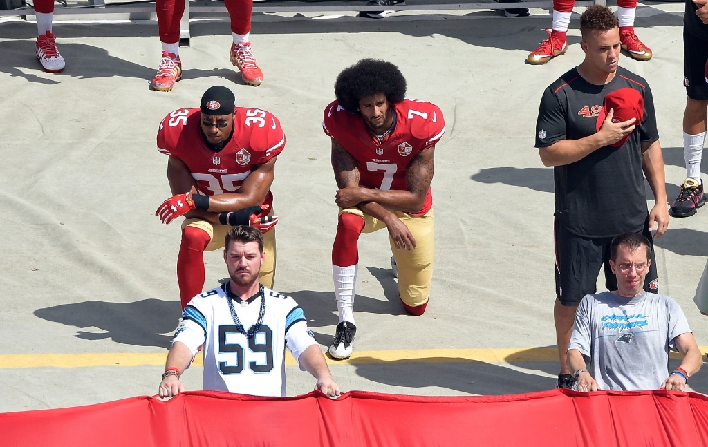 Colin Kaepernick No. 7 and Eric Reid No. 35 of the San Francisco 49ers kneel during the national anthem before their game against the Carolina Panthers at Bank of America Stadium on Sept. 18 2016 in Charlotte N.C