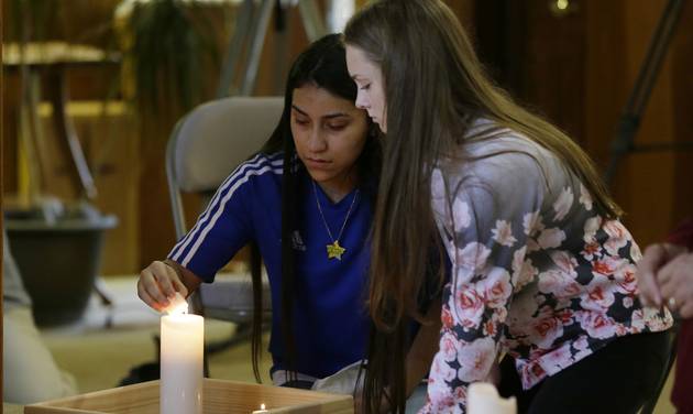 Rachel Marsh 15 right and Selena Orozco 15 left light candles as they attend a prayer service Saturday Sept. 24 2016 at the Central United Methodist Church in Sedro-Woolley Wash. The service was held in reaction to Friday's fatal shooting