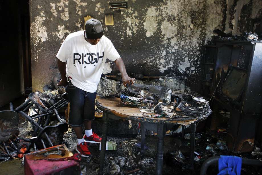 Frederick Terrell a friend of the fire victims looks at debris from the blaze inside the home