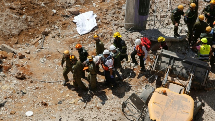 Israeli medics carry a wounded person away on a stretcher after an underground car park collapsed in the Ramat Hahayal neighbourhood of Tel Aviv