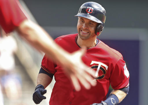 Minnesota Twins&#039 Brian Dozier smiles as the third base coach reaches out to congratulate him as he jogs the base path on a solo home run off Kansas City Royals pitcher Ian Kennedy in the first inning of a baseball game Monday Sept. 5 2016 in Minne