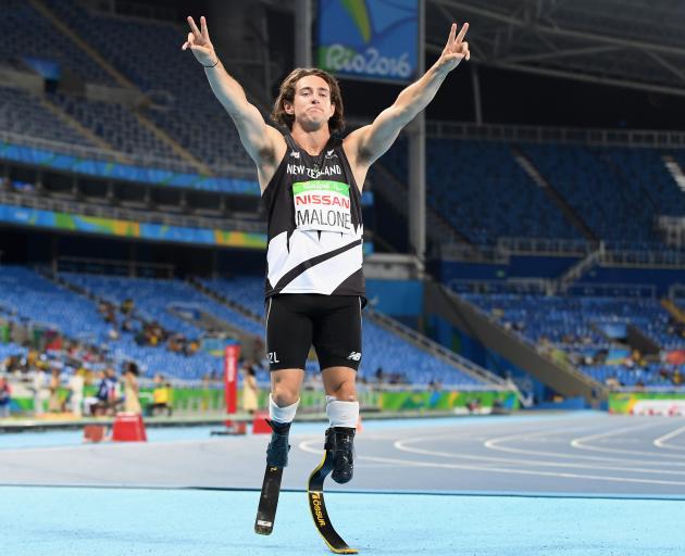 Liam Malone celebrates winning gold in the 200m T44 race at Maracena Stadium