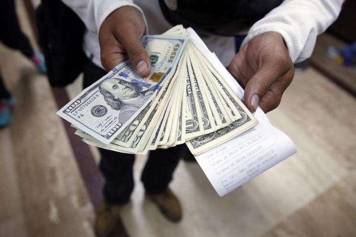 A man poses with dollars after buying them at a money exchange in Caracas Febreuary 24 2015. REUTERS  Carlos Garcia Rawlins