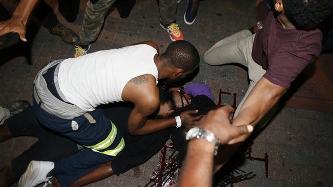 Protesters tend to a protester shot in the parking area of the Omni Hotel during a march to protest the death of Keith Scott