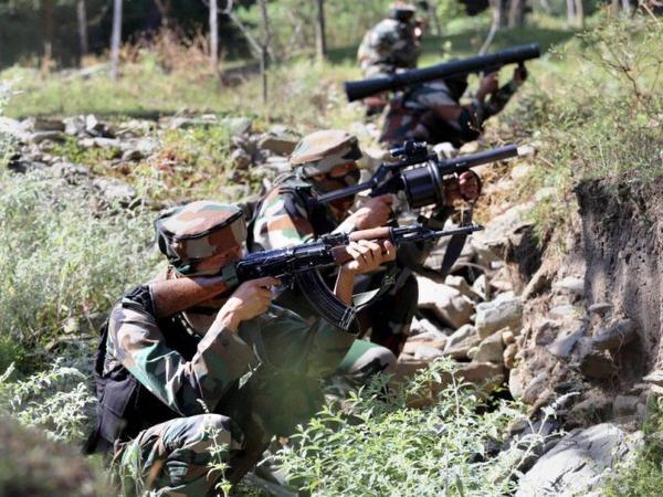 Army personnel take positions during an encounter with the militants near the Line of Control in Uri