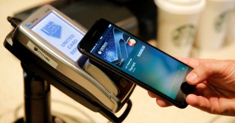 A man uses an iPhone 7 smartphone to demonstrate the mobile payment service Apple Pay at a cafe in Moscow. Reuters