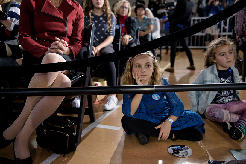 People listen as Democratic presidential nominee Hillary Clinton speaks during a town hall meeting