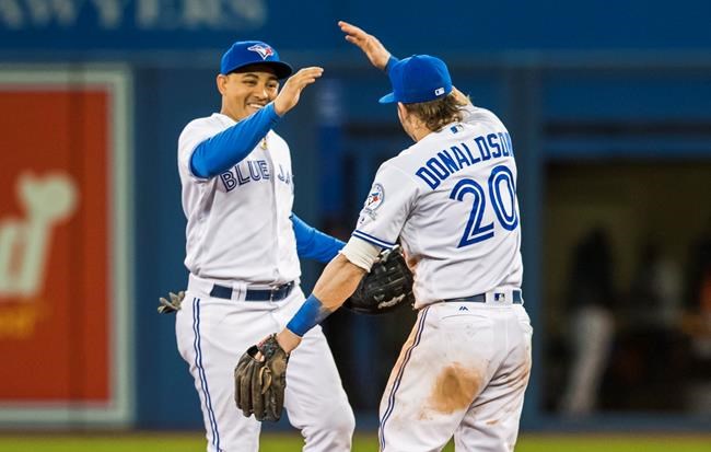 Toronto Blue Jays&#39 Josh Donaldson and Ezequiel Carrera celebrate their team's win over the Baltimore Orioles in MLB baseball action in Toronto Tuesday