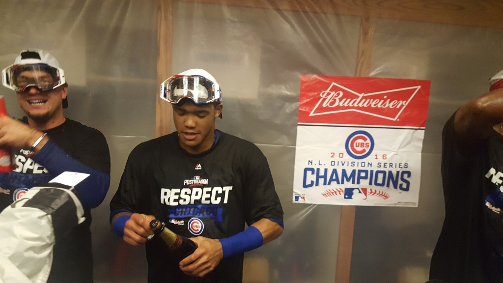 Cubs shortstop Addison Russell opens a bottle of champagne after clinching the NLDS