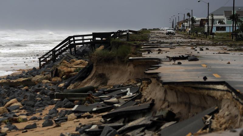 An official vehicle navigates debris as it passes along Highway A1A after it was partial washed away by Hurricane Matthew in Flagler Beach