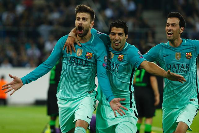 Barcelona`s defender Gerard Pique celebrates scoring the 1-2 goal with his teammates Uruguayan forward Luis Suarez and midfielder Sergio Busquets during the UEFA Champions League first-leg group C football match between Borussia Moenchengladbach and F