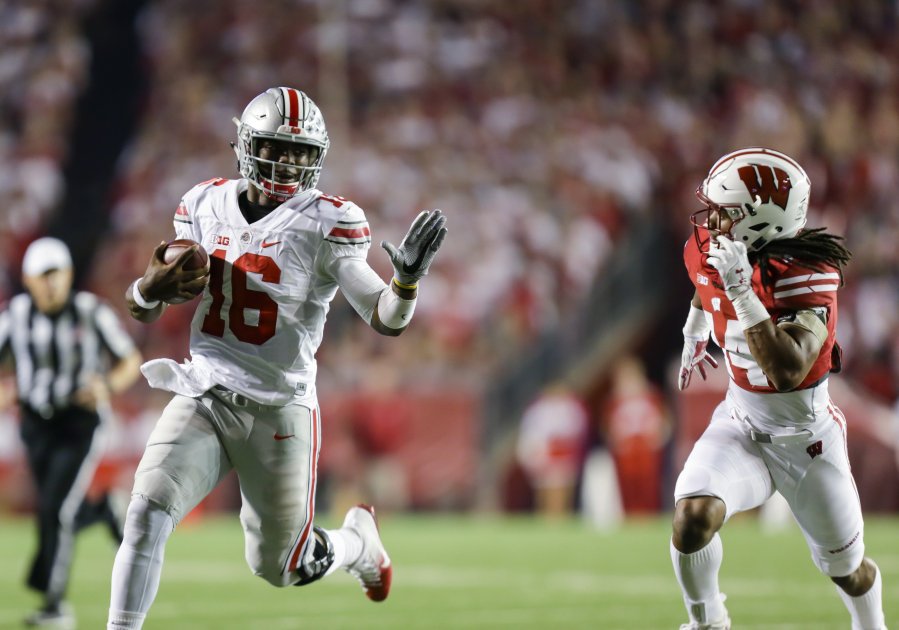 Ohio State quarterback J.T. Barrett scrambles Saturday against Wisconsin's D'Cota Dixon during the Buckeyes&apos 30-23 overtime victory