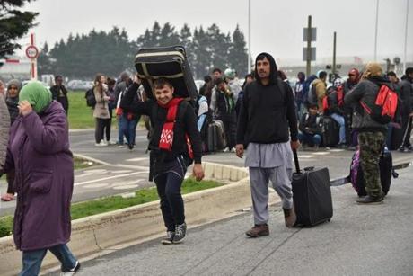 Philippe Huguen  AFP  Getty Images		Migrants with their luggage lined up to leave the migrant camp in Calais Monday