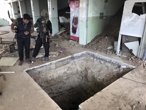 A soldier with Iraq's elite counterterrorism force left inspects a tunnel made by Islamic State militants in Bartella Iraq Thursday Oct. 27 2016. The town of Bartella in northern Iraq lays about 20 kilometres east