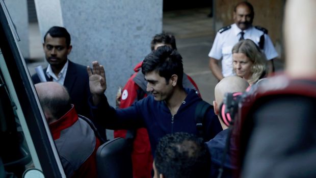 A young migrant waves as leaves the headquarters of UK Visas and Immigration in Croydon south London on Monday