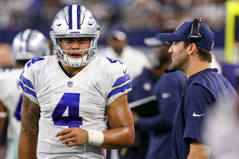 ARLINGTON TX- OCTOBER 30 Dallas Cowboys Quarterback Dak Prescott warms up prior to overtime with Quarterback Tony Romo looking on during the NFL game between the Philadelphia Eagles and Dallas Cowboys