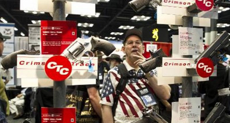 Convention goers check out handguns equipped with Crimson Trace laser sights at the 143rd NRA Annual Meetings and Exhibits at the Indiana Convention Center in Indianapolis Indiana