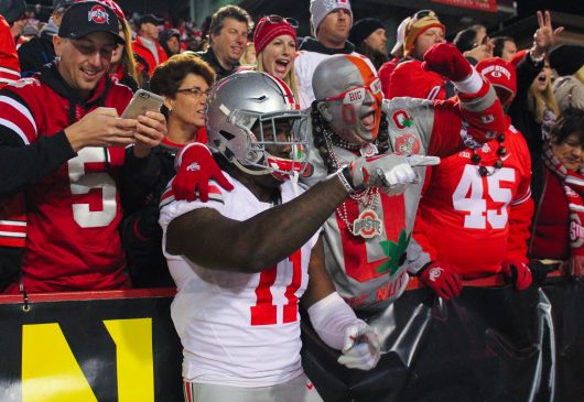 OSU redshirt junior defensive end Jalyn Holmes celebrates with the Big Nut and other Buckeye fans following the Buckeyes 62-3 win over Maryland on Nov. 12. Credit Alexa Mavrogianis