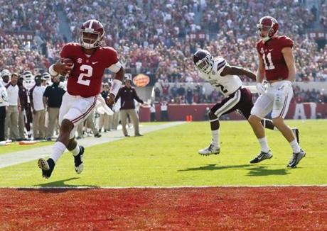 Alabama quarterback Jalen Hurts left scores a touchdown during the first half of an NCAA college football game against Mississippi State Saturday Nov. 12 2016 in Tuscaloosa Ala