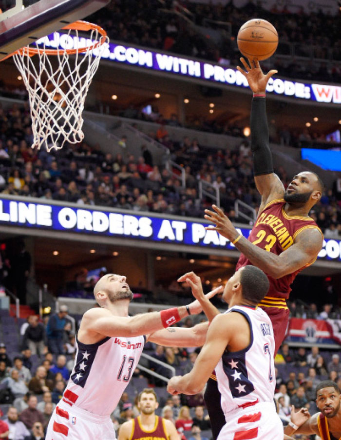 Cleveland Cavaliers’ Le Bron James shoots against Washington Wizards’ center Marcin Gortat and Otto Porter Jr. during their NBA game in Washington Friday. — AP