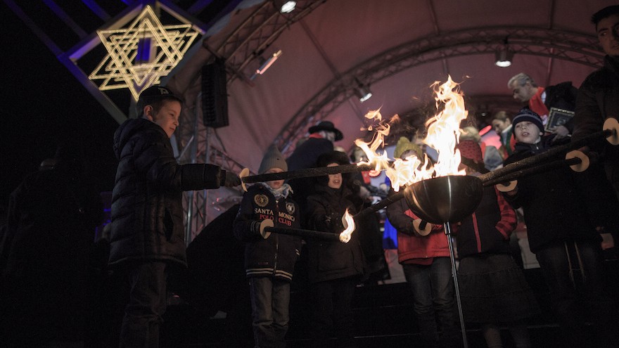 Children light torches at the ceremony of the Hanukkah menorah lighting at a public Menorah ceremony near the Brandenburg Gate