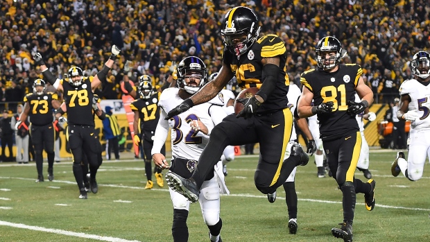 Le'Veon Bell of the Pittsburgh Steelers leaps into the end zone in front of Eric Weddle of the Baltimore Ravens for a seven-yard rushing touchdown in the fourth quarter at Heinz Field in Pittsburgh on Sunday