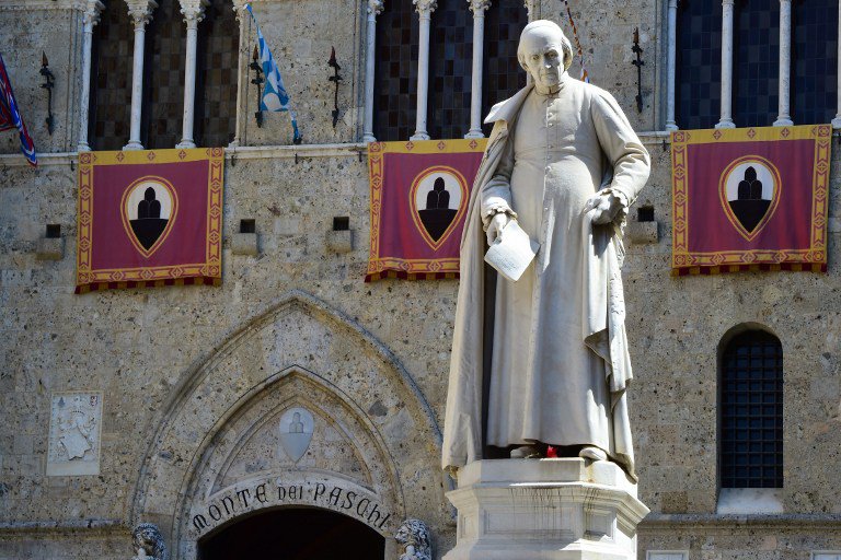 2 2016 shows a statue of priest Sallustio Bandini at Piazza Salimbeni the headquarters of the Monte dei Paschi di Siena bank in Siena Tuscany. Sallustio Bandini is one of the