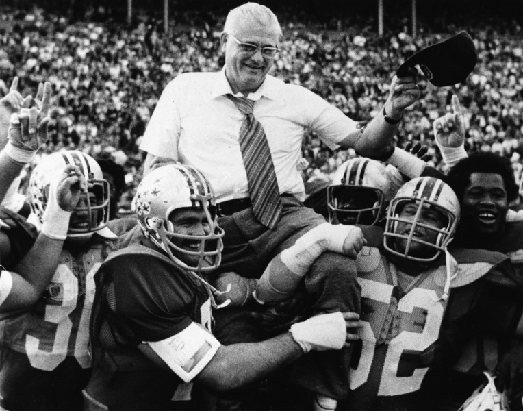 Ohio State football coach Woody Hayes tips his cap as members of the Buckeyes carry him off the field following a 49-7 victory over Illinois in Columbus Ohio. Hayes and Bear Bryant of Alabama might watch their