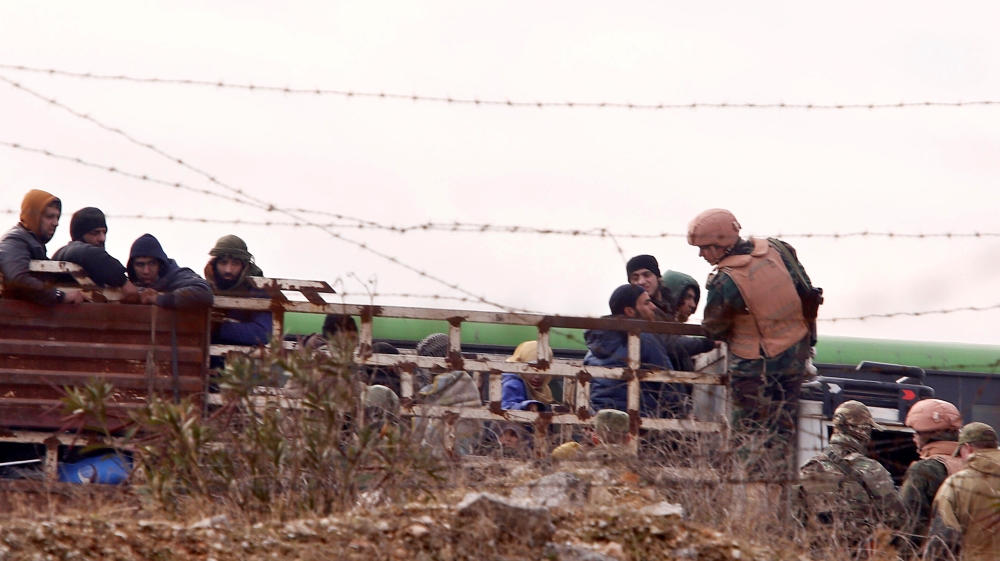 Russian soldiers inspect rebels and civilians who were evacuated from rebel-held eastern Aleppo