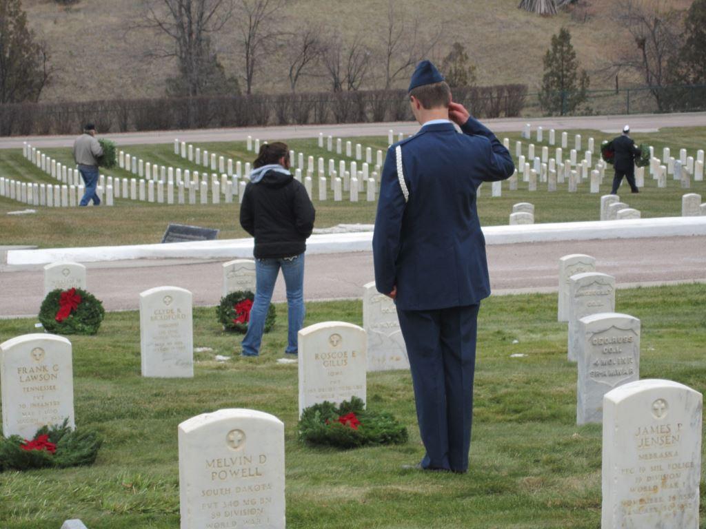 A U.S. Air Force airman salutes the grave of a veteran after he’s laid a wreath at the V.A. National Cemetery in Hot Springs S.D. in 2015