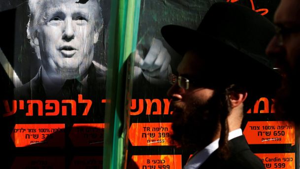 An ultra Orthodox Jewish man walking next to a poster of Donald Trump in Jerusalem's Mea She'arim neighborhood October 2016