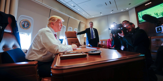 Loading President Donald Trump sits at his desk on Air Force One upon his arrival at Andrews Air Force Base