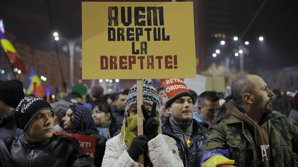 A girl holds a banner that reads