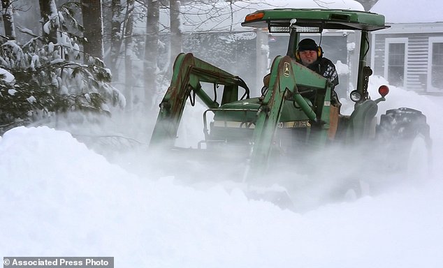 Alan Boucher uses a farm tractor to dig out of his driveway during a blizzard Monday Feb. 13 2017 in Freeport Maine. Snow up to two feet deep blanketed parts of the Northeast just days after the biggest storm of the season dumped up to 19 inches