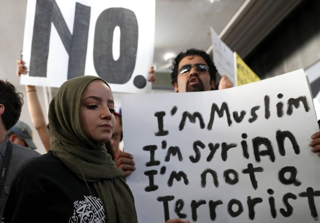 Protesters hold signs during a demonstration against the immigration ban that was imposed by U.S. President Donald Trump at Los Angeles International Airport