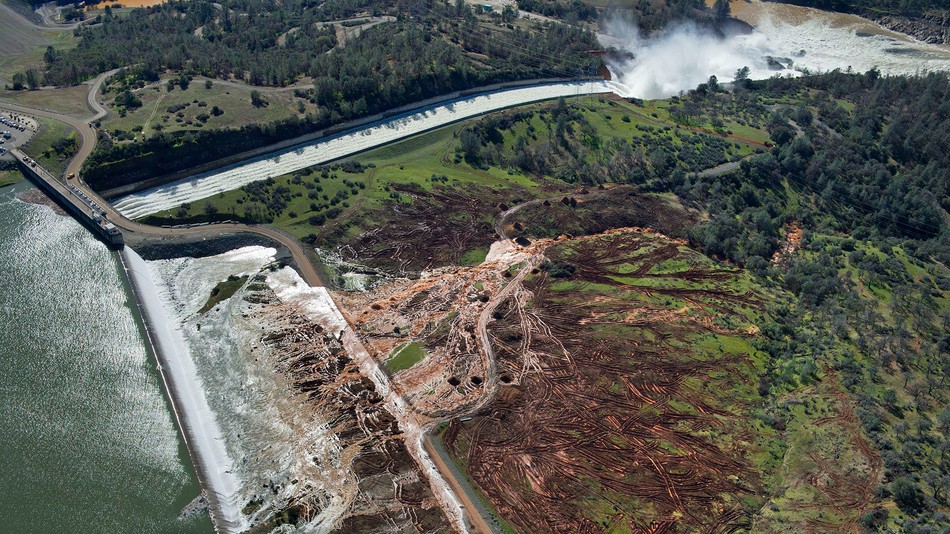 Lake water flows over the emergency spillway bottom left at Lake Oroville for the first time in the Oroville Dam's nearly 50-year history Feb. 11 2017