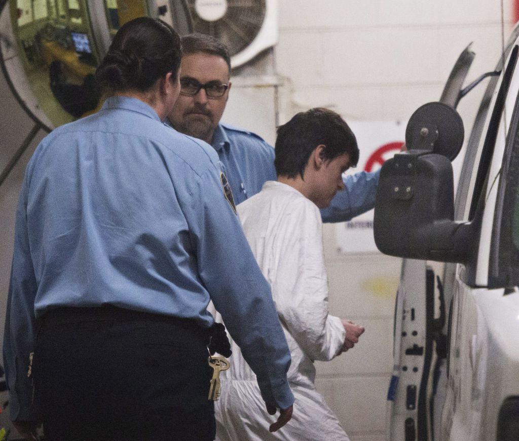 Alexandre Bissonnette is escorted to a van Monday Jan. 30 2017 in Quebec City after appearing in court for Sunday's deadly shooting at a mosque