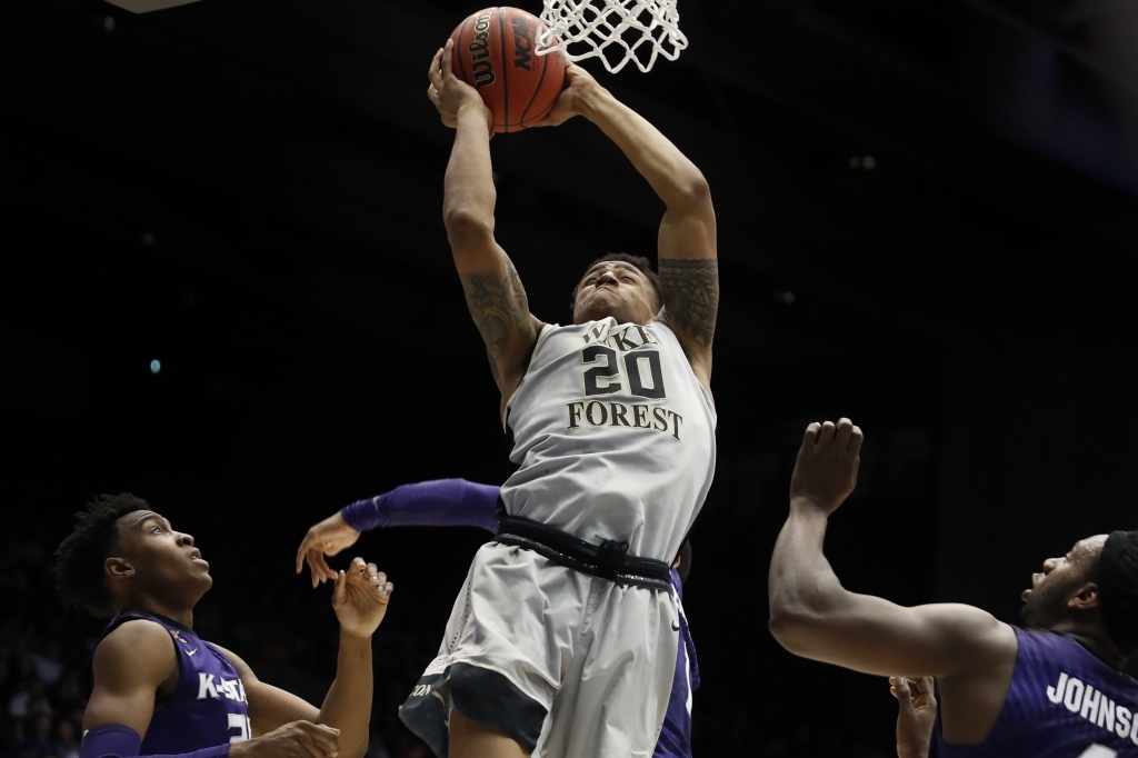 Wake Forest's John Collins shoots against Kansas State's Wesley Iwundu left and D.J. Johnson right in the first half of a First Four game of the NCAA college basketball tournament Tuesday