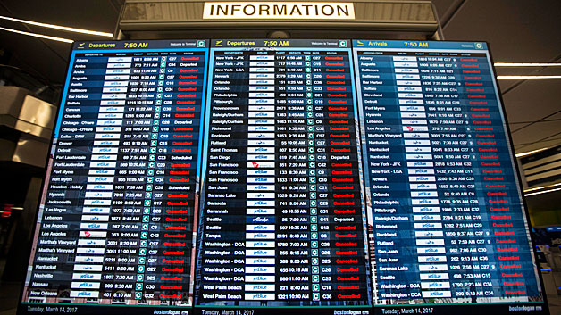 The information board in Terminal C at Logan International Airport shows the majority of flights cancelled