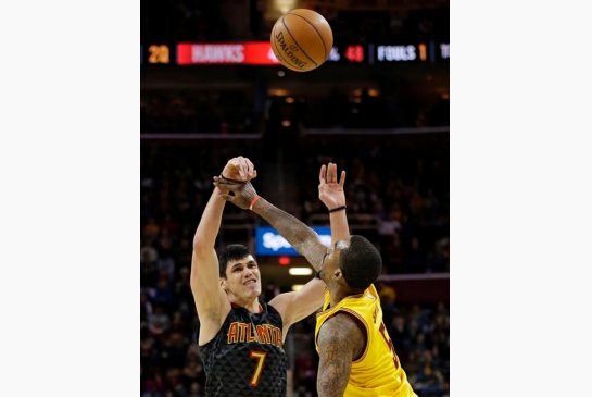 Atlanta Hawks Ersan Ilyasova, from Turkey passes over Cleveland Cavaliers J.R. Smith in the first half of an NBA basketball game Friday